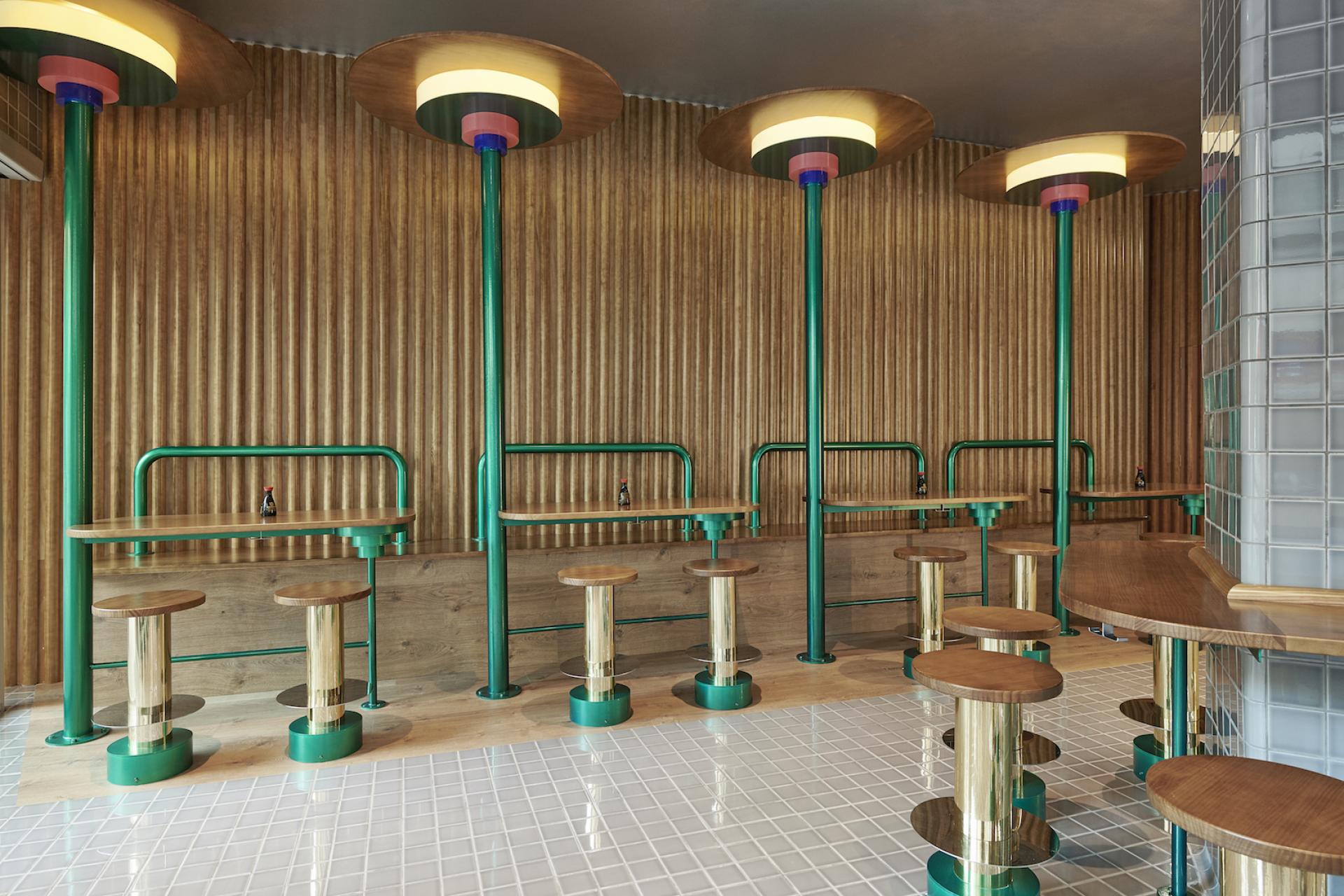 Modern interior design of Kento Gran Vía sushi takeaway, featuring stylish tables and unique circular lighting accents.