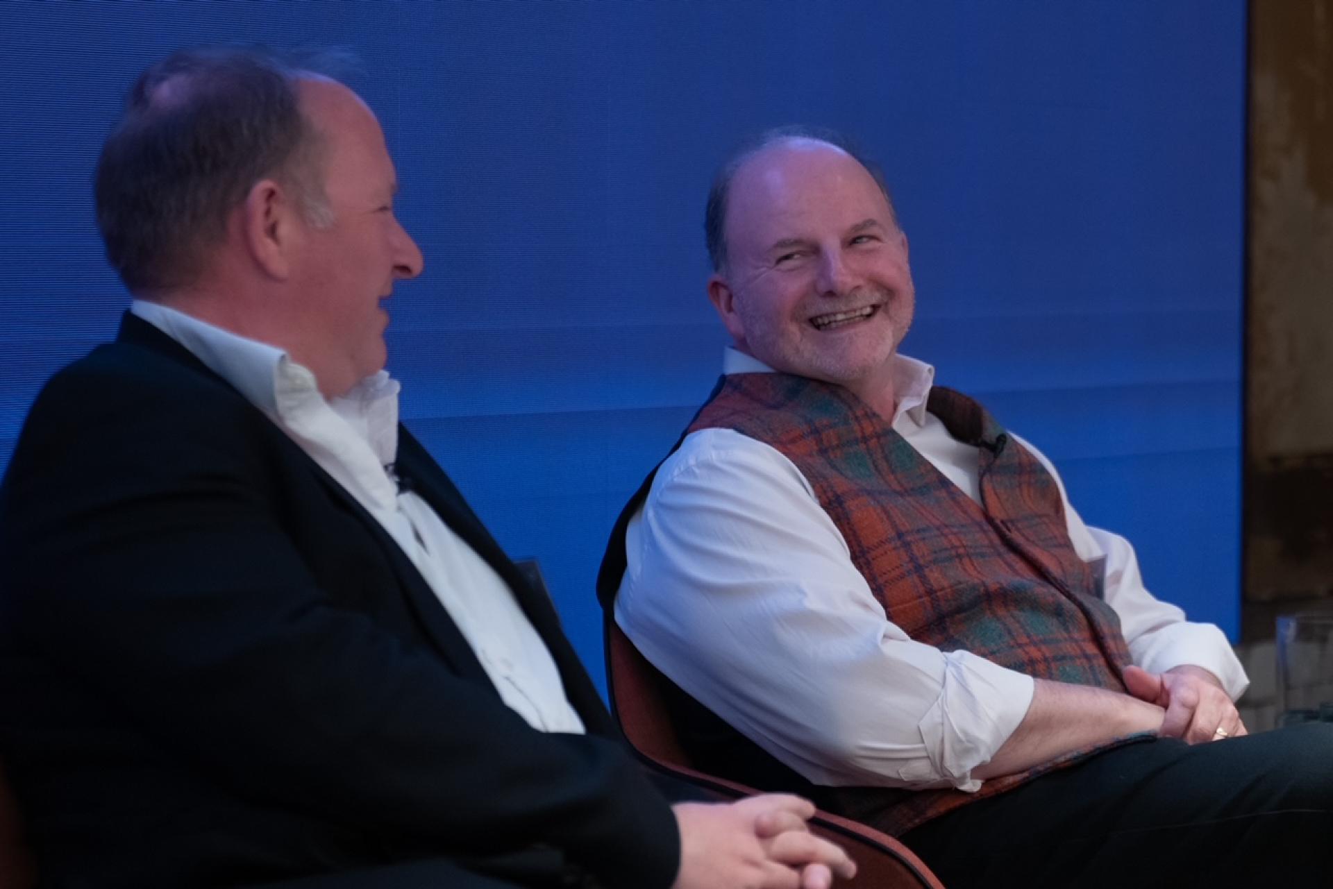 Two speakers engaged in discussion at the Material Source Studio seminar on hospitality brand and experience.