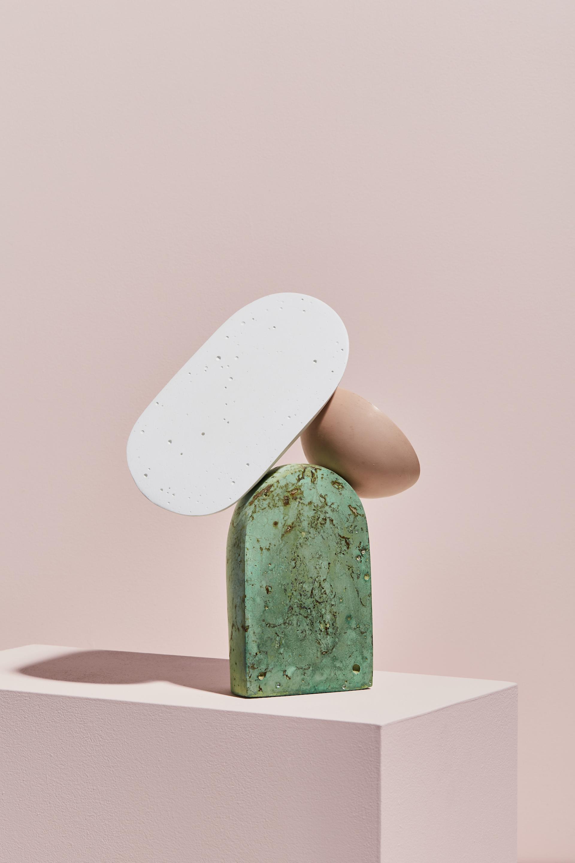 Abstract sculpture by Vic Wright featuring green stone, white and pink forms on a minimal pedestal against a pastel backdrop.