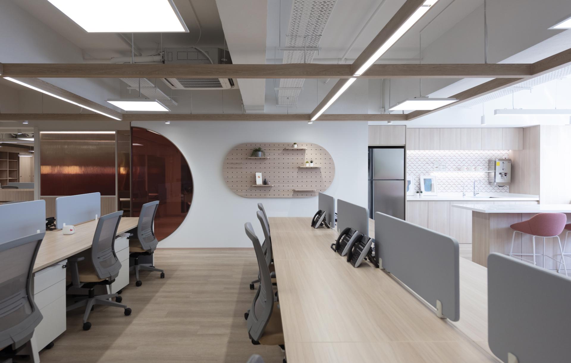 Modern office workspace at Unicorn Stores HQ featuring sleek desks, ergonomic chairs, and a contemporary kitchen area.