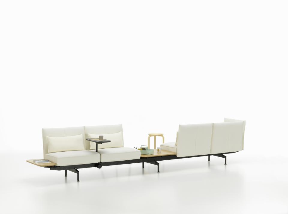 Modern soft seating system by Vitra featuring modular design and integrated tables for collaborative workspaces.