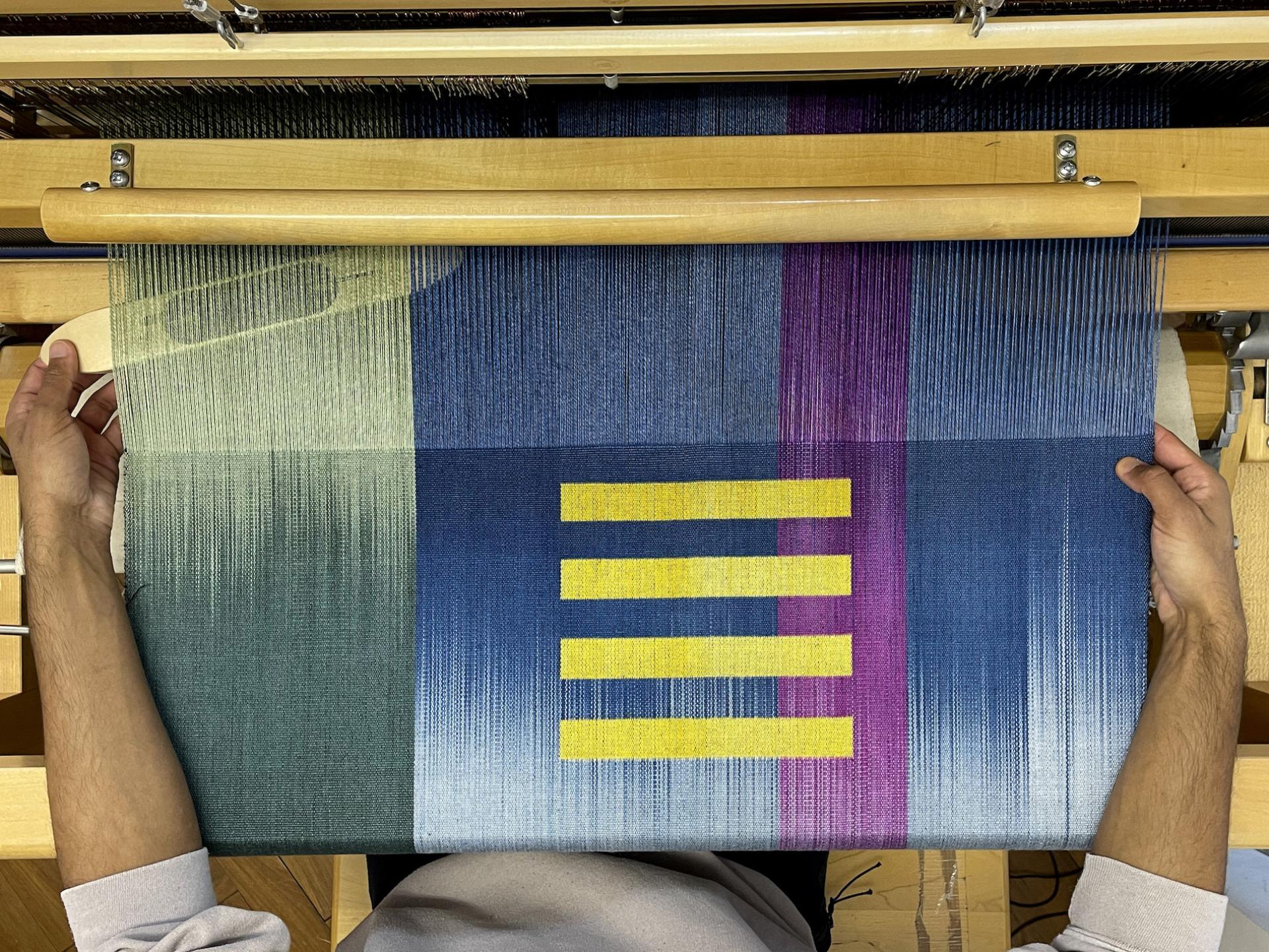 Colorful woven textile being crafted on a loom, showcasing vibrant patterns and textures at Cockpit Arts Summer Festival.
