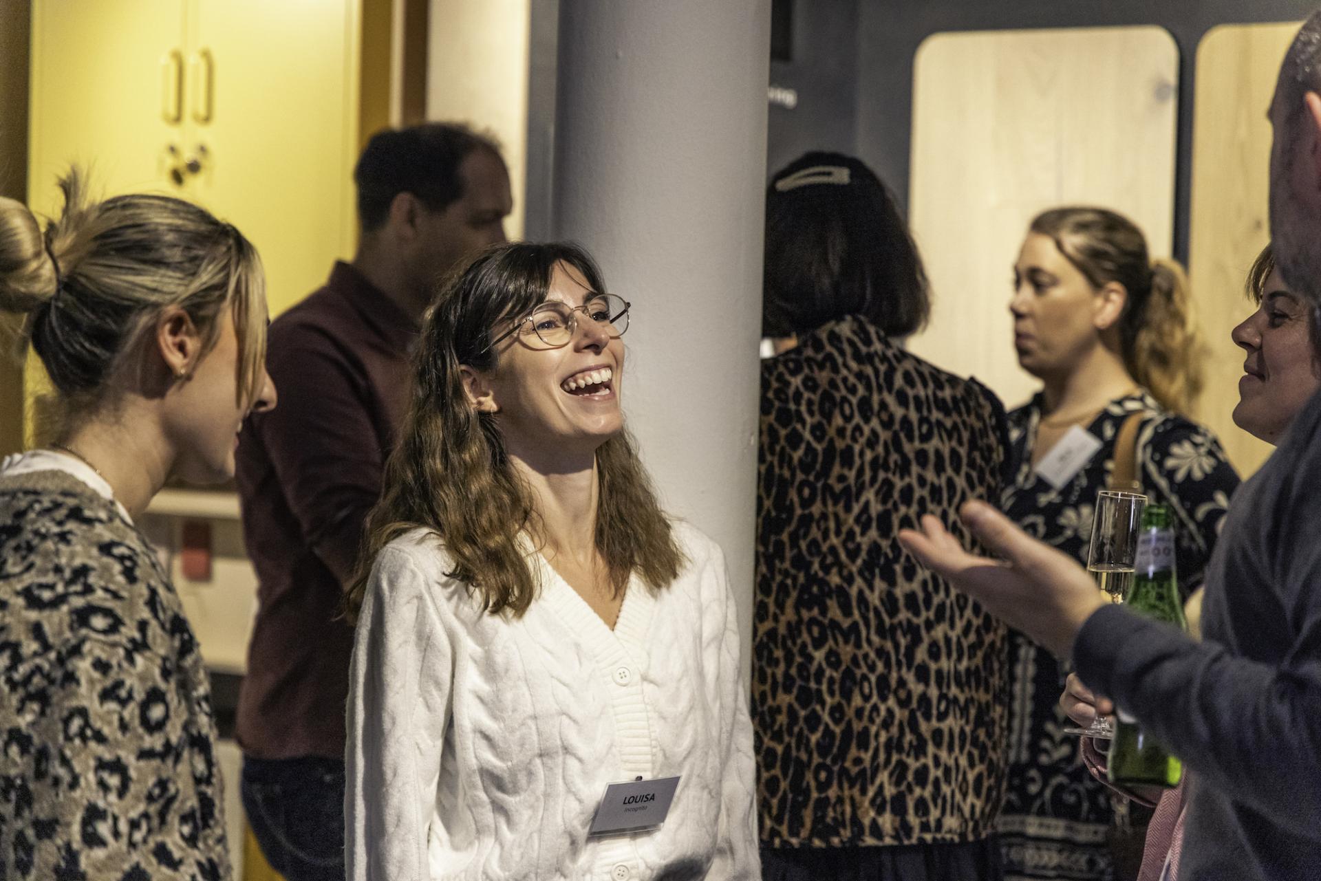 Colleagues engaging in lively conversation at a workplace event focused on technology and collaboration.