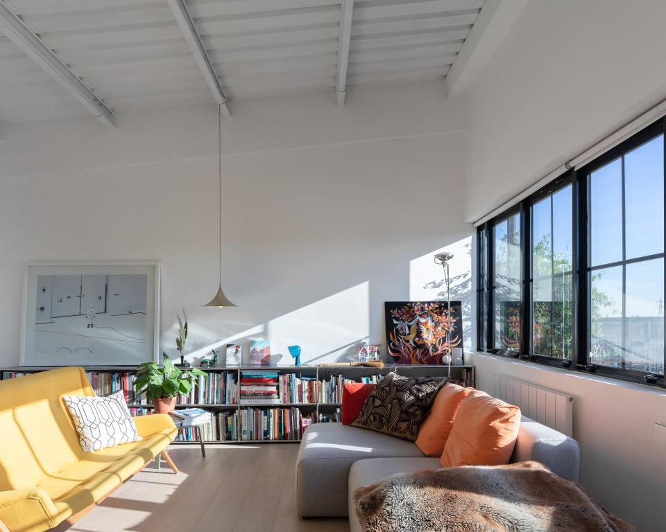 Stylish studio flat interior showcasing art deco design, bright natural light, and a cozy reading area with bookshelves.