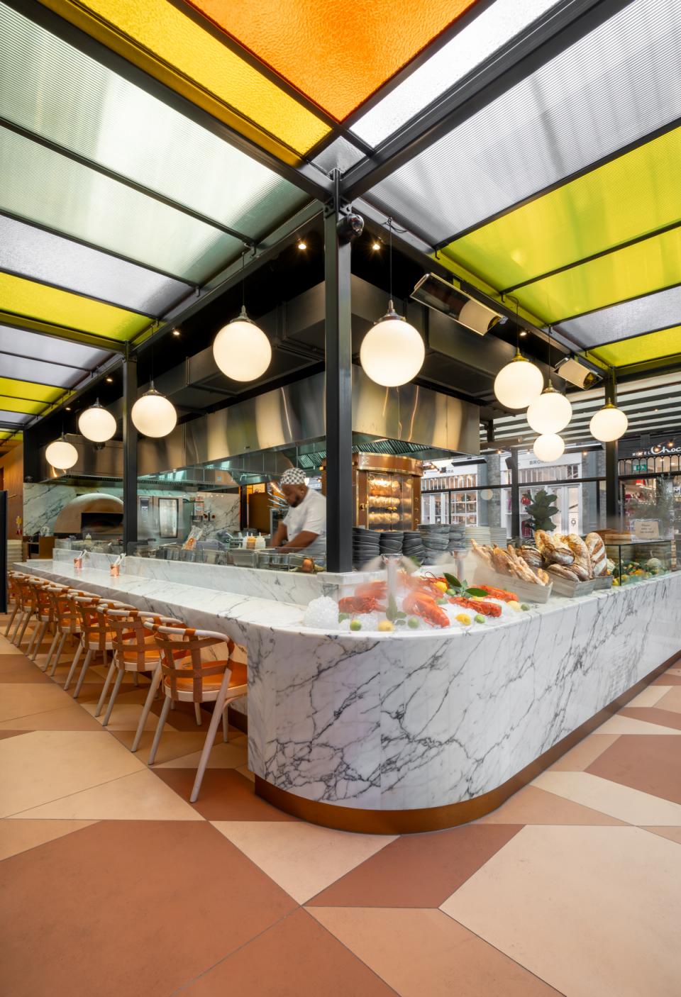Vibrant interior of Buns & Buns restaurant featuring a marble counter, colorful ceiling, and fresh seafood display.
