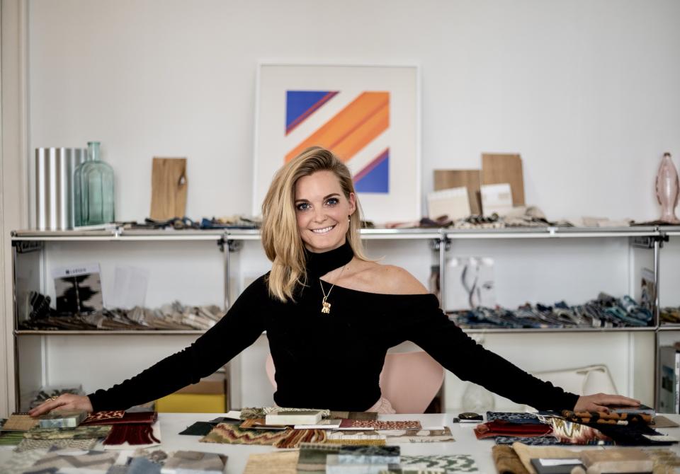 Theresa Obermoser showcases colorful fabric swatches in her interior design studio, highlighting her creative design process.