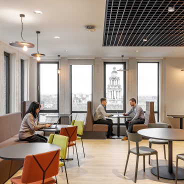 Modern interior design showcasing a collaborative workspace in Stopford House, featuring elegant furnishings and city views.