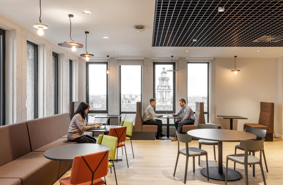 Modern interior design showcasing a collaborative workspace in Stopford House, featuring elegant furnishings and city views.