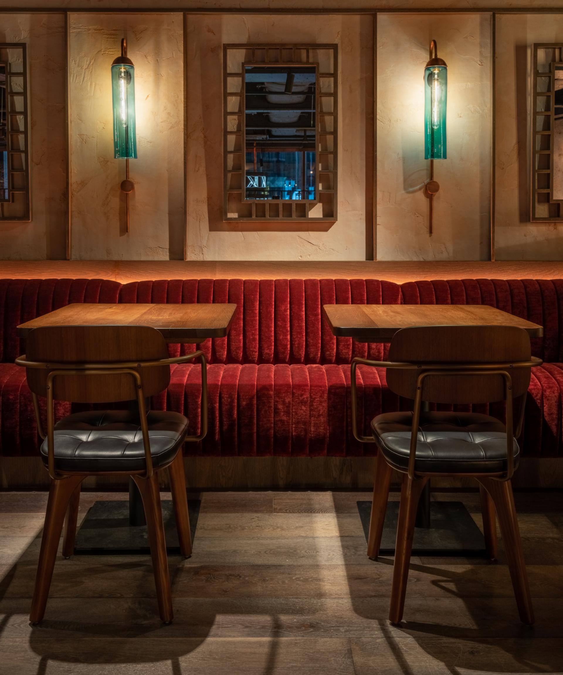 Elegant restaurant interior featuring plush red seating, wooden tables, and stylish lighting designed by Michaelis Boyd for Andrew Wong.