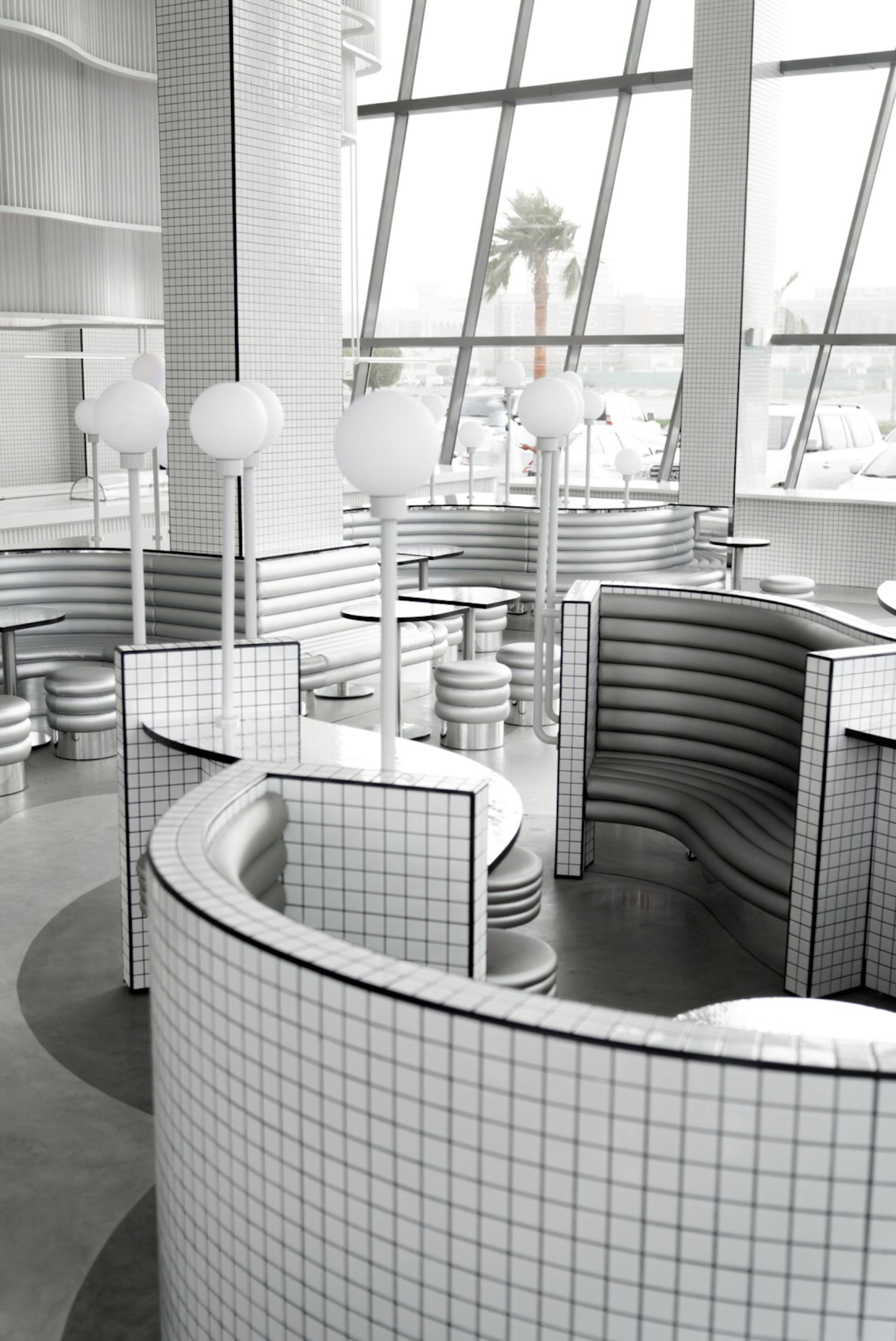 Modern cafe interior design featuring curved booths, sleek finishes, and geometric lighting at MO bakehouse in Khobar.