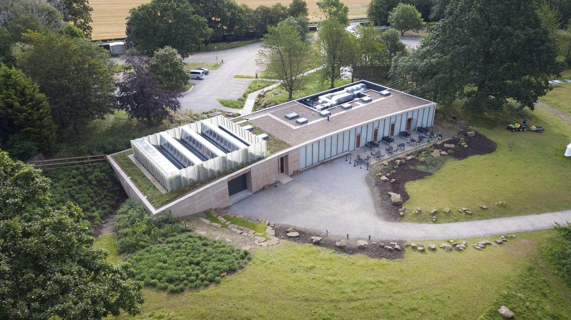 Sustainable visitor centre at Yorkshire Sculpture Park, featuring a green roof and modern design harmonizing with nature.