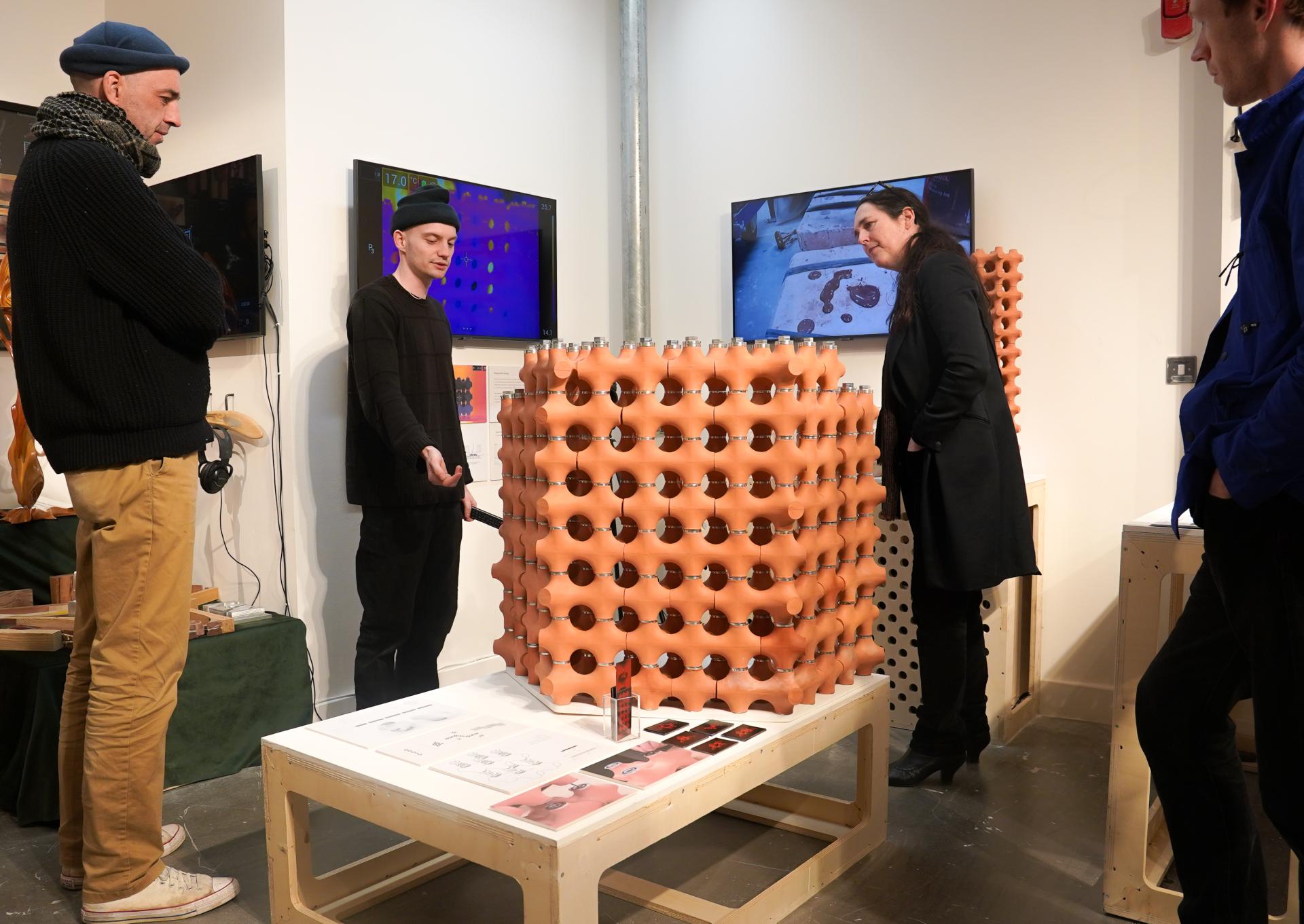 Graduates present TerraCool, an innovative terracotta cooling solution, during a design exhibition with interactive displays.