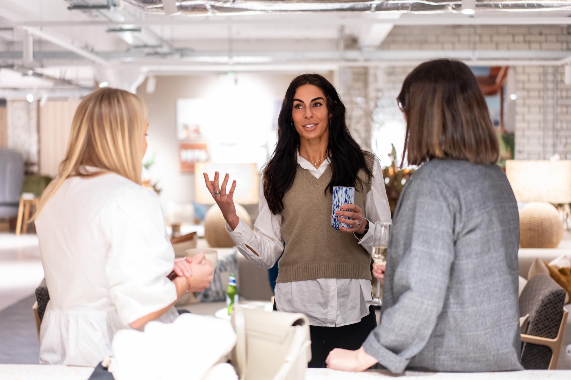 Women engaged in a conversation about EDI culture in a modern studio environment, showcasing collaboration and inclusivity.