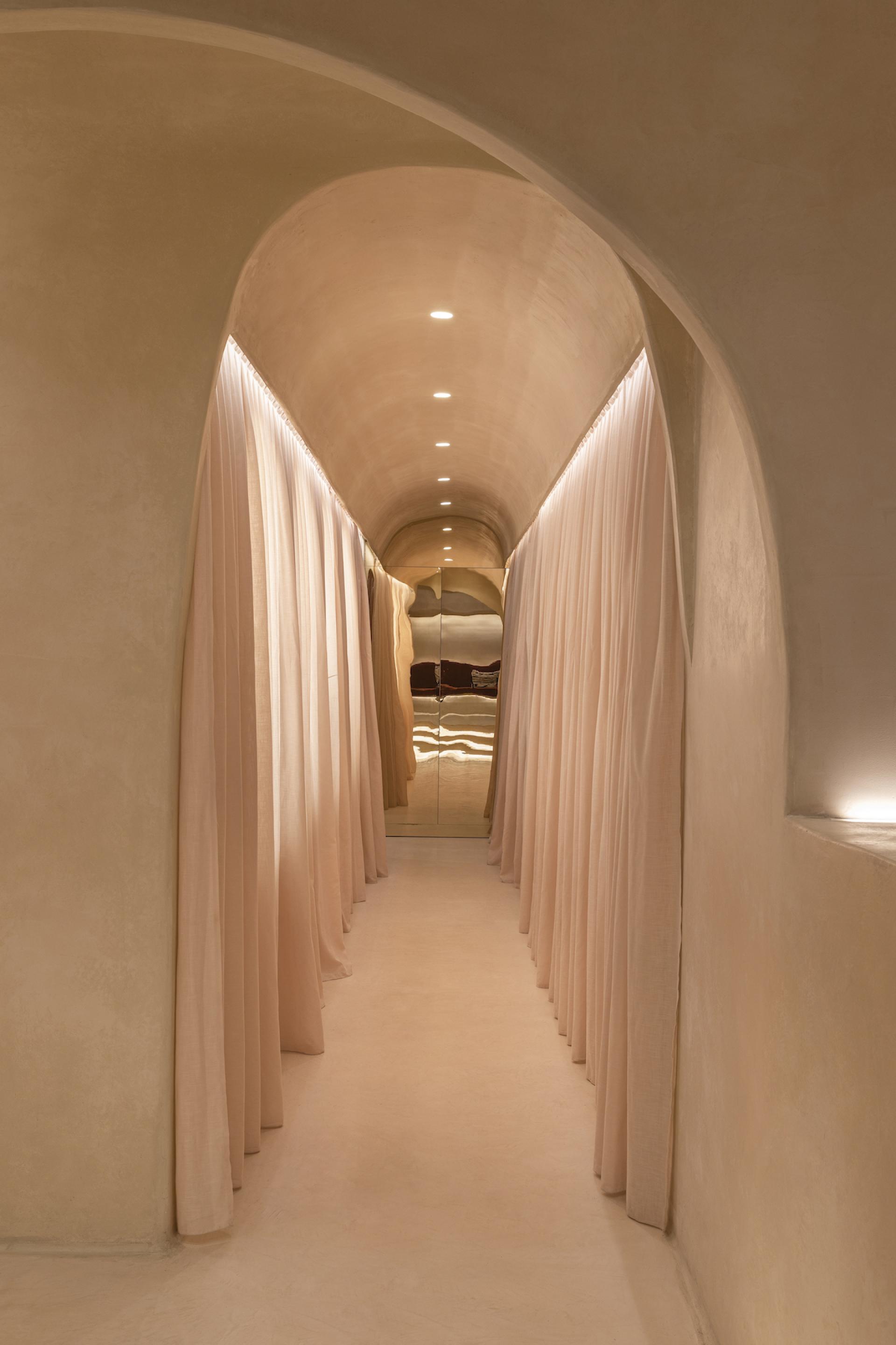Elegant arched corridor featuring soft beige walls and flowing curtains, reflecting Middle Eastern design elements at Living Bakkali restaurant.
