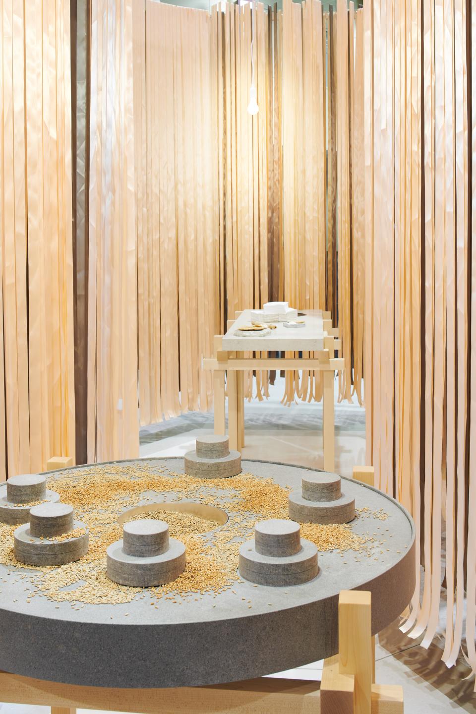 Exhibition space featuring a circular table with grains, showcasing the collaboration between Caesarstone and Marije Vogelzang on food design.