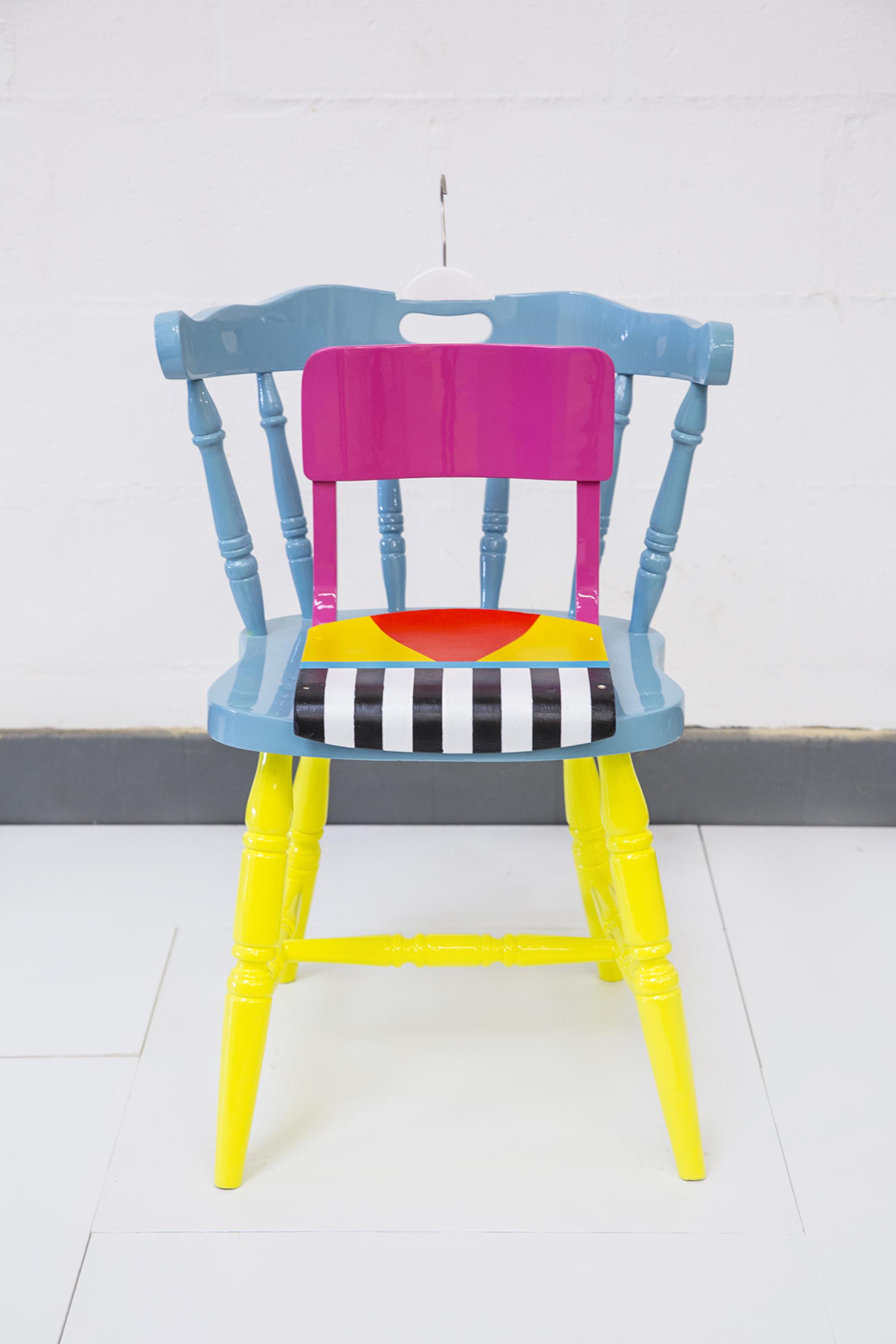 Colorful, upcycled chair designed by Yinka Ilori, showcasing vibrant colors and playful patterns in contemporary furniture design.