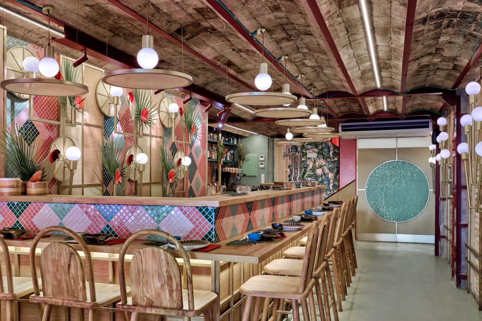 Vibrant interior design of Kaikaya, Valencia's tropical sushi restaurant, featuring colorful decor and a welcoming bar area.