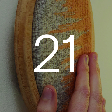 Hand touching a textured light switch with the number "21," representing Emma Harriet Wright's exploration of technology and afterlife themes.