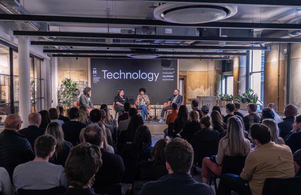 Panel discussion on technology at Material Source Studio, featuring speakers and an engaged audience in a modern setting.
