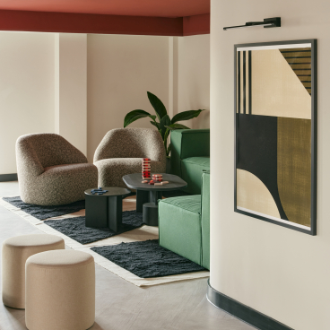 Contemporary lounge area featuring stylish furniture, art, and greenery, showcasing innovative design from Karndean Commercial and PLATFORM_.