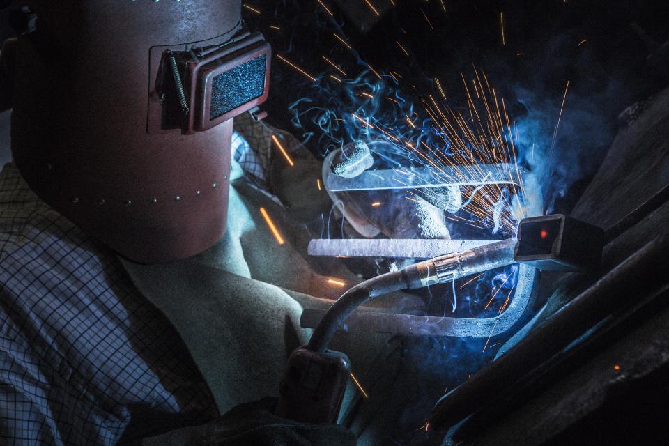 Craftsman welding metal with sparks and smoke, showcasing traditional metal craftsmanship from Tsubame-Sanjo at Japan House London.