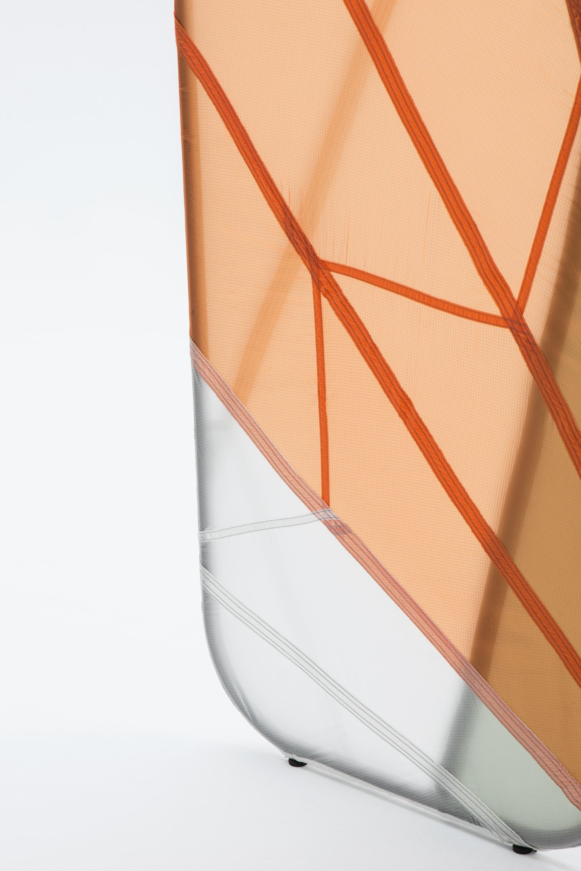 Innovative furniture design featuring recycled parachute material and a welded steel frame, showcasing a unique geometric structure.