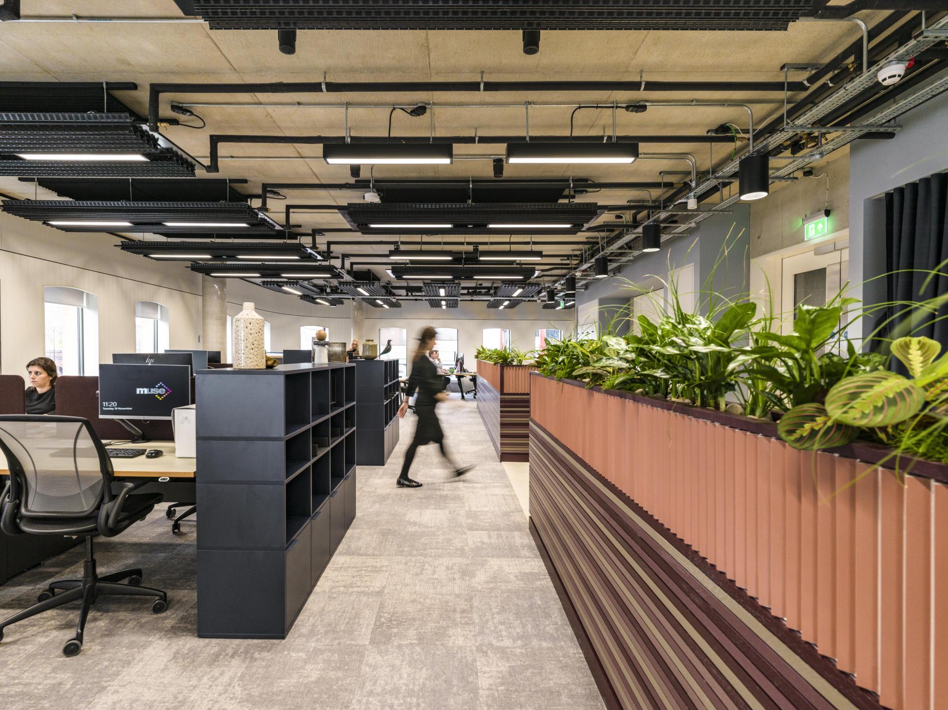 Contemporary office interior at Riverside House featuring plants, workstations, and modern design elements by SpaceInvader.