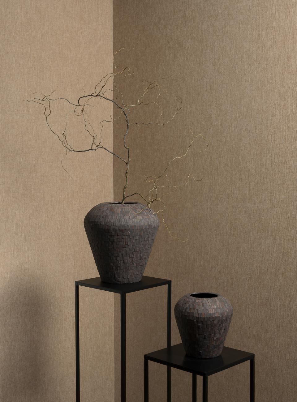Modern decorative vases with branches, set against Arte's stylish wallcoverings in beige tones for spring 2025.