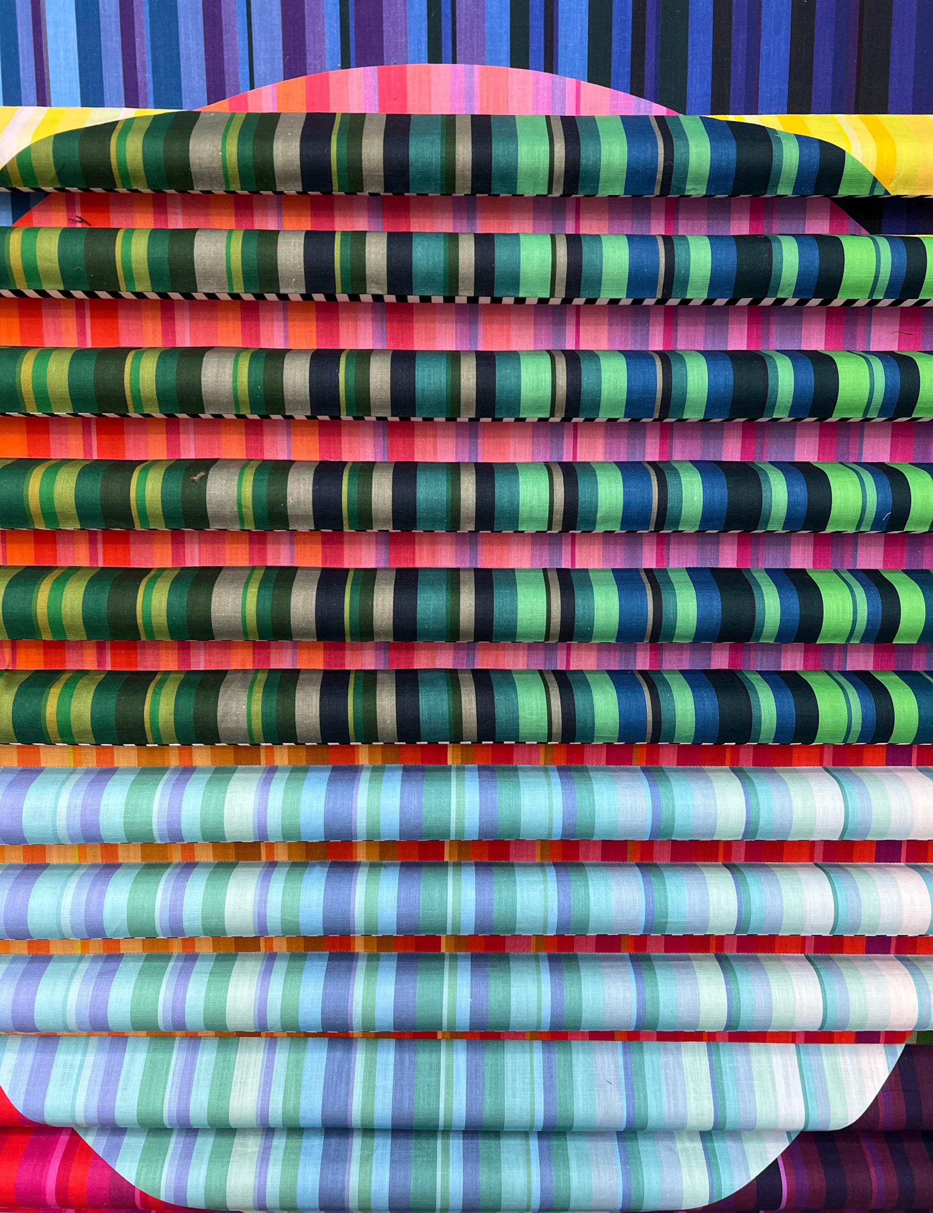 Colorful textile design featuring vibrant stripes in green, blue, and pink, showcasing Margo Selby's artistic style.