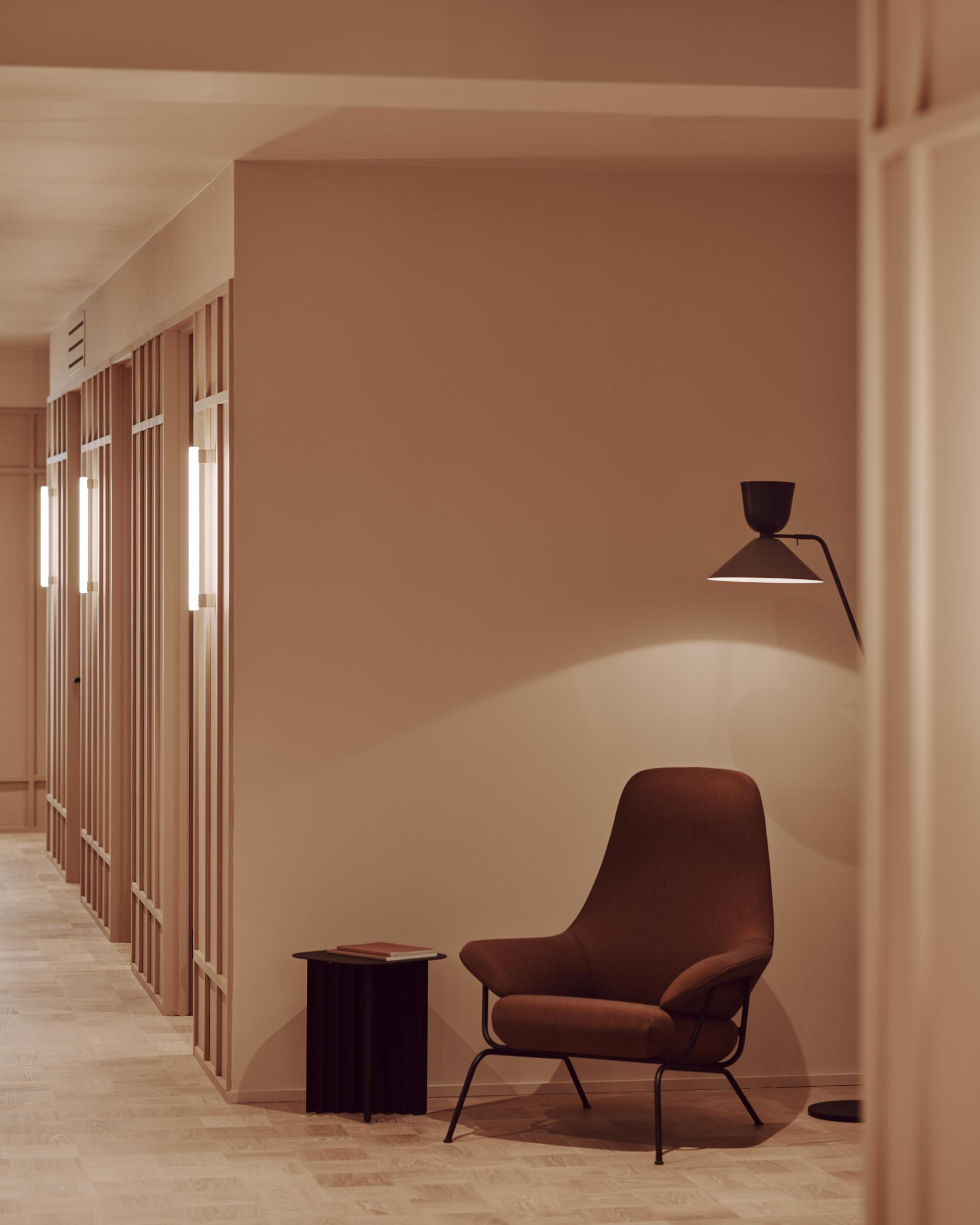 Calm and stylish workspace in Summit House featuring a cozy armchair, modern lamp, and sleek wooden flooring.