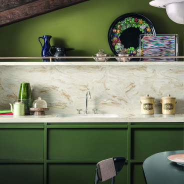 Stylish kitchen featuring elegant green cabinetry, marble countertops, and decorative accents reflecting modern surface design trends.