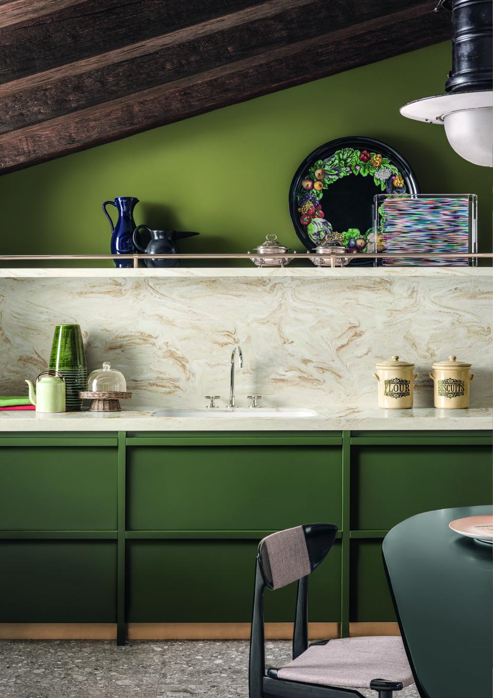 Stylish kitchen featuring elegant green cabinetry, marble countertops, and decorative accents reflecting modern surface design trends.