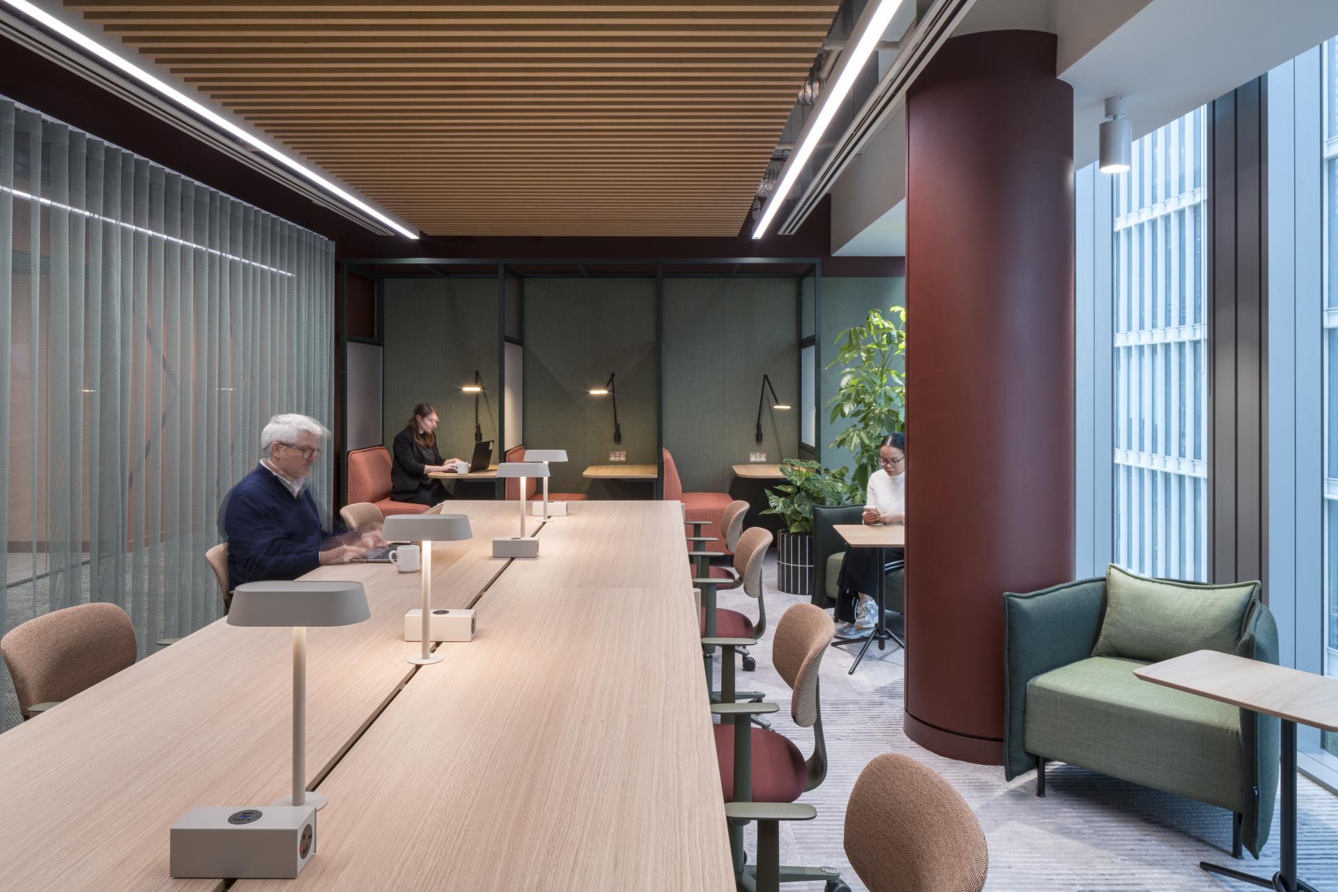 Modern collaborative workspace in Virgin Media O2's new London HQ, featuring sustainable design elements and flexible seating arrangements.