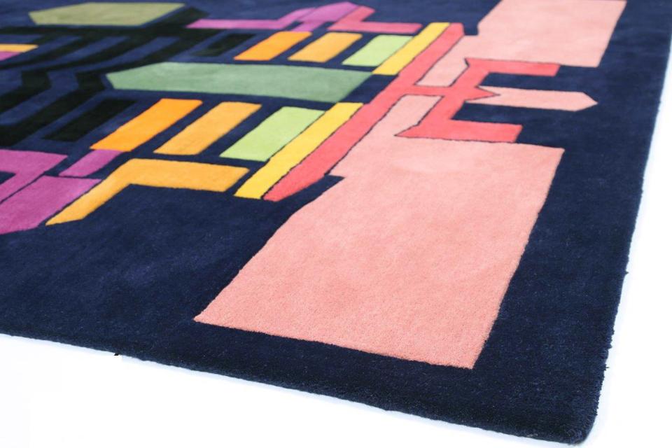 Vibrant geometric rug featuring bold colors and patterns, showcasing the collaboration between Dharma Taylor and Paul Smith.