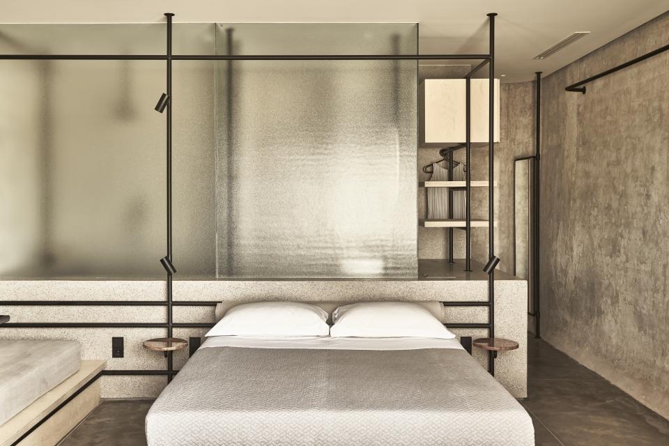 Modern bedroom design within a repurposed wine tank featuring textured concrete and minimalist decor on the Peloponnese peninsula.