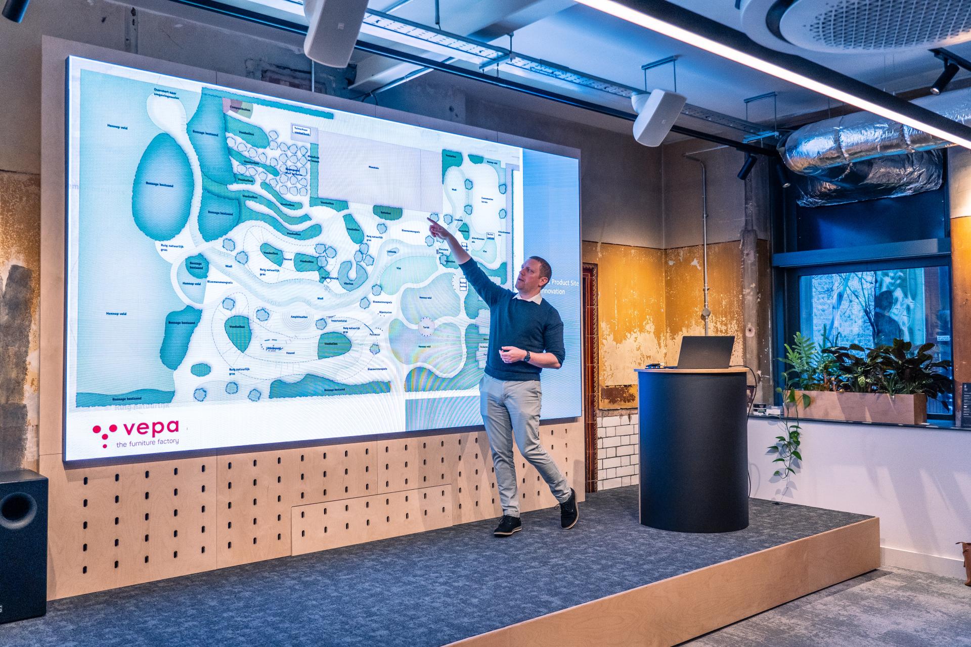 A presenter explains sustainable design concepts using a digital landscape plan during MMU's Green Week event.
