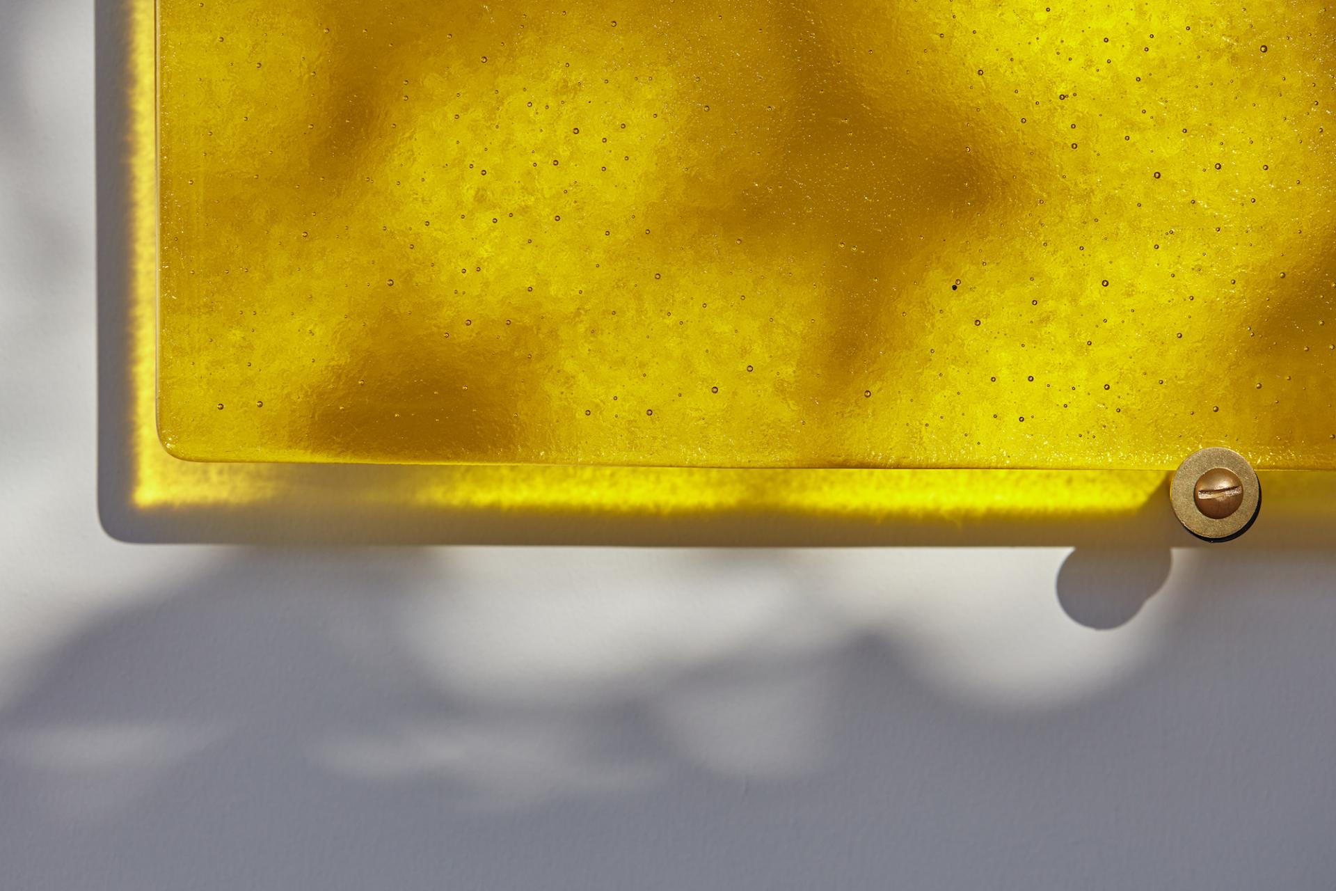 Translucent yellow panel casting abstract shadows, highlighting innovative design at a prominent design event celebrating color insights.
