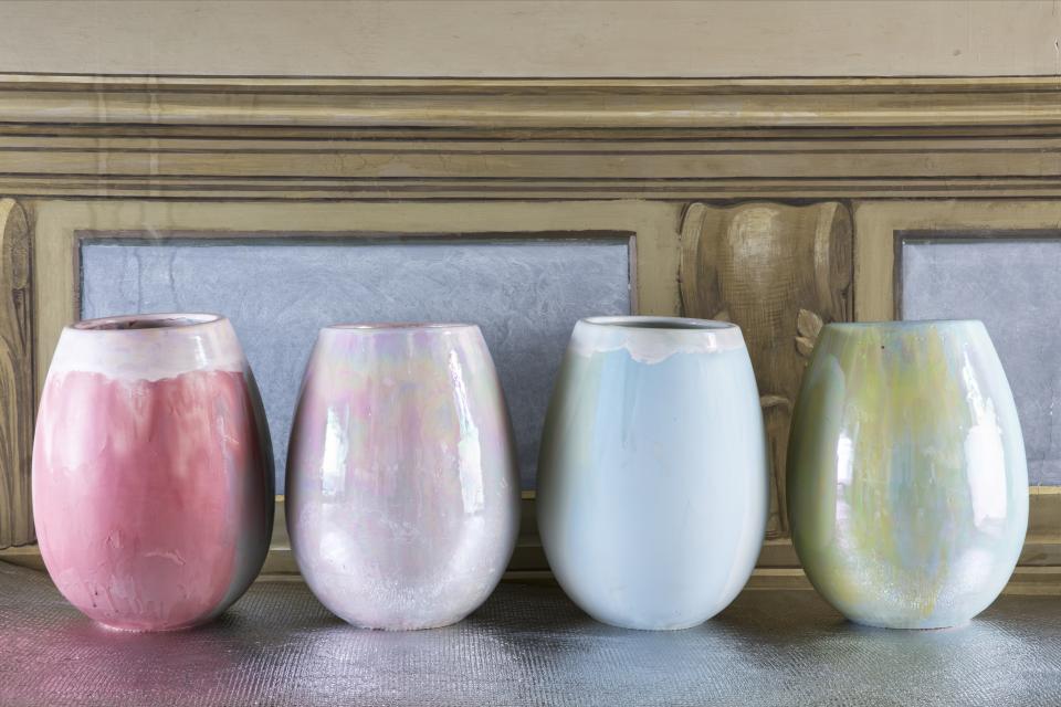Hand-decorated ceramic and porcelain vases in pastel colors, showcasing Coralla Maiuri's unique artisanal design.