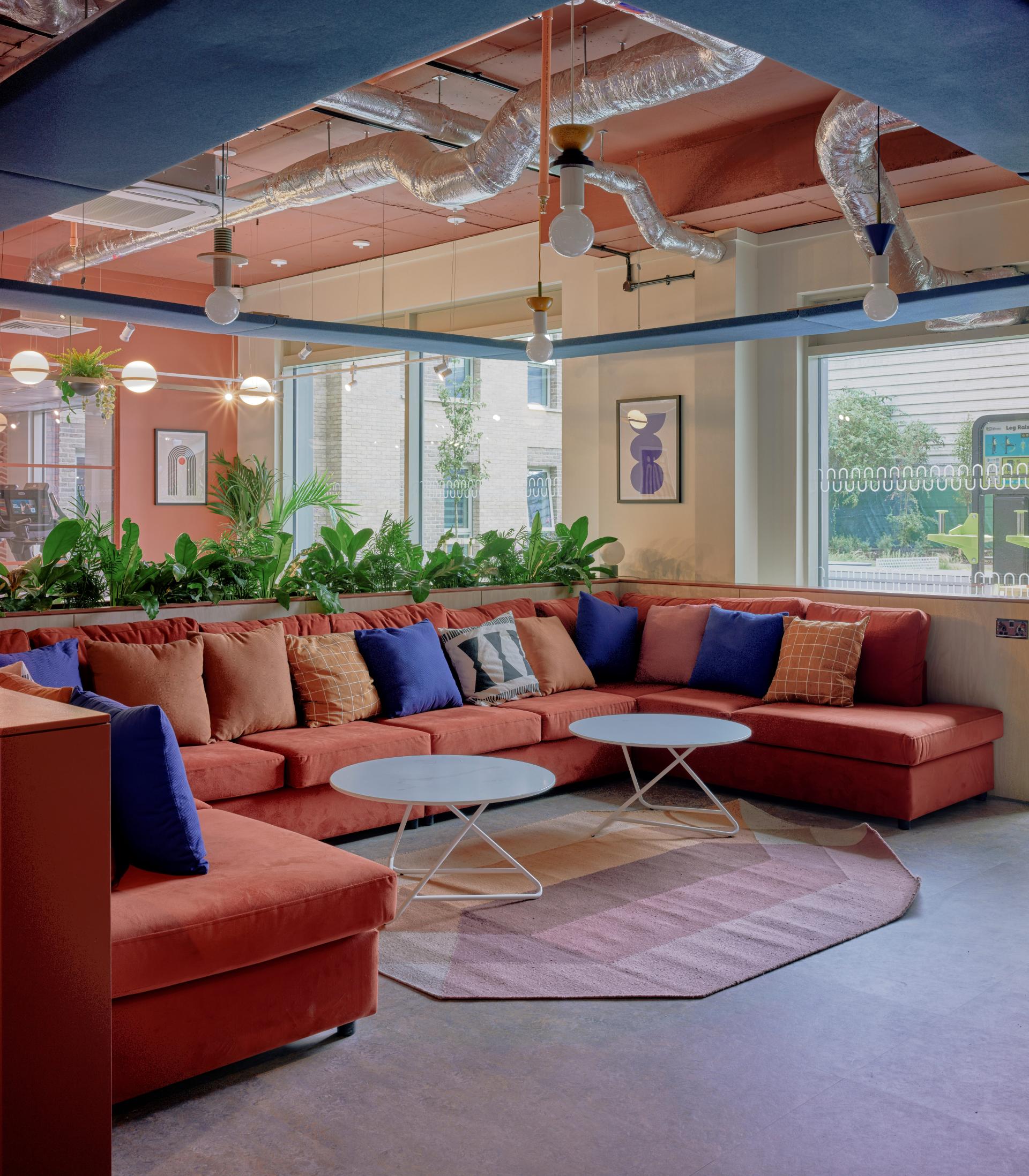 Stylishly designed lounge area in Enso, featuring vibrant cushions, plants, and modern decor reflecting Colchester's contemporary living.