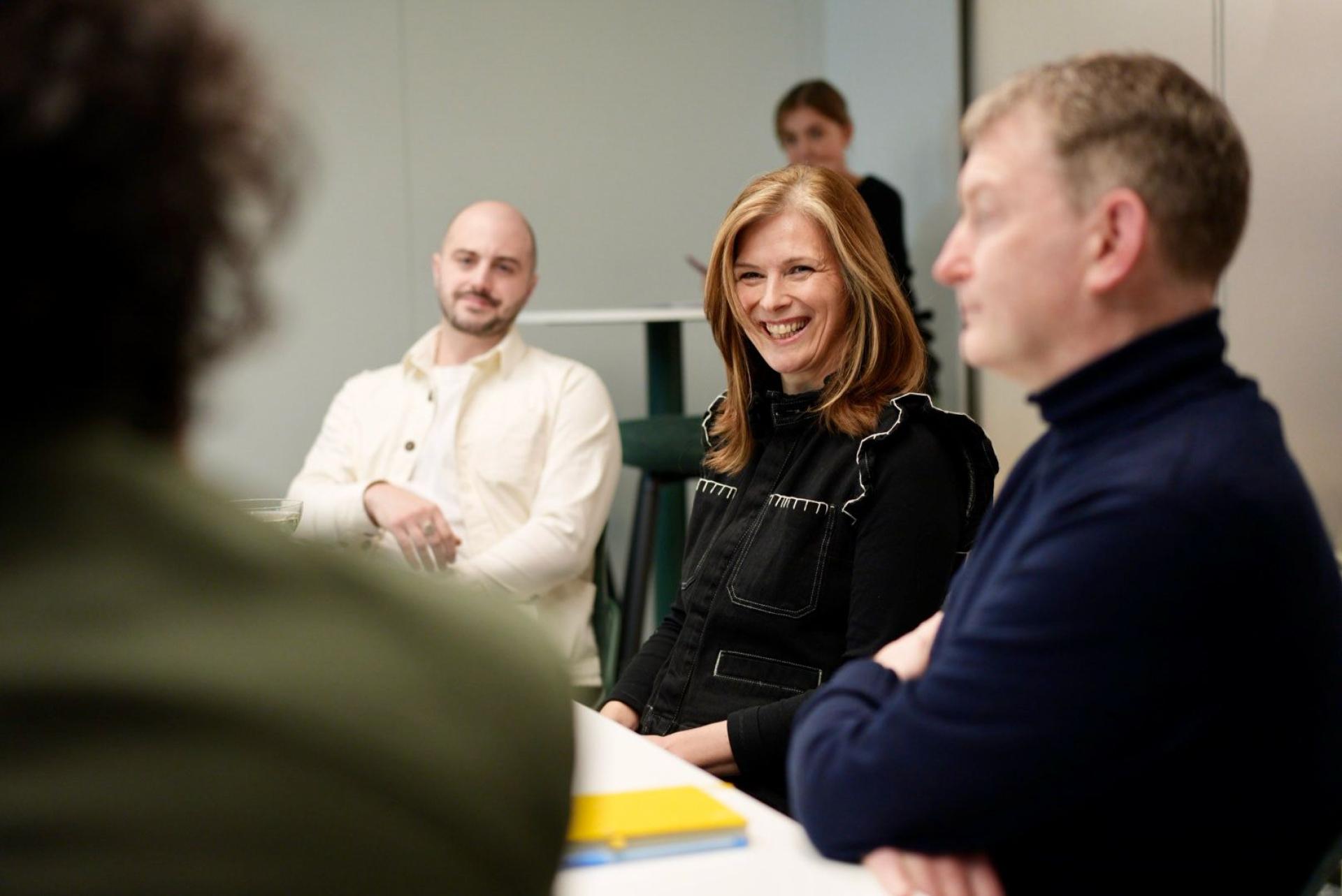 Team members engage in a lively discussion about workplace flexibility, highlighting the importance of employee satisfaction.