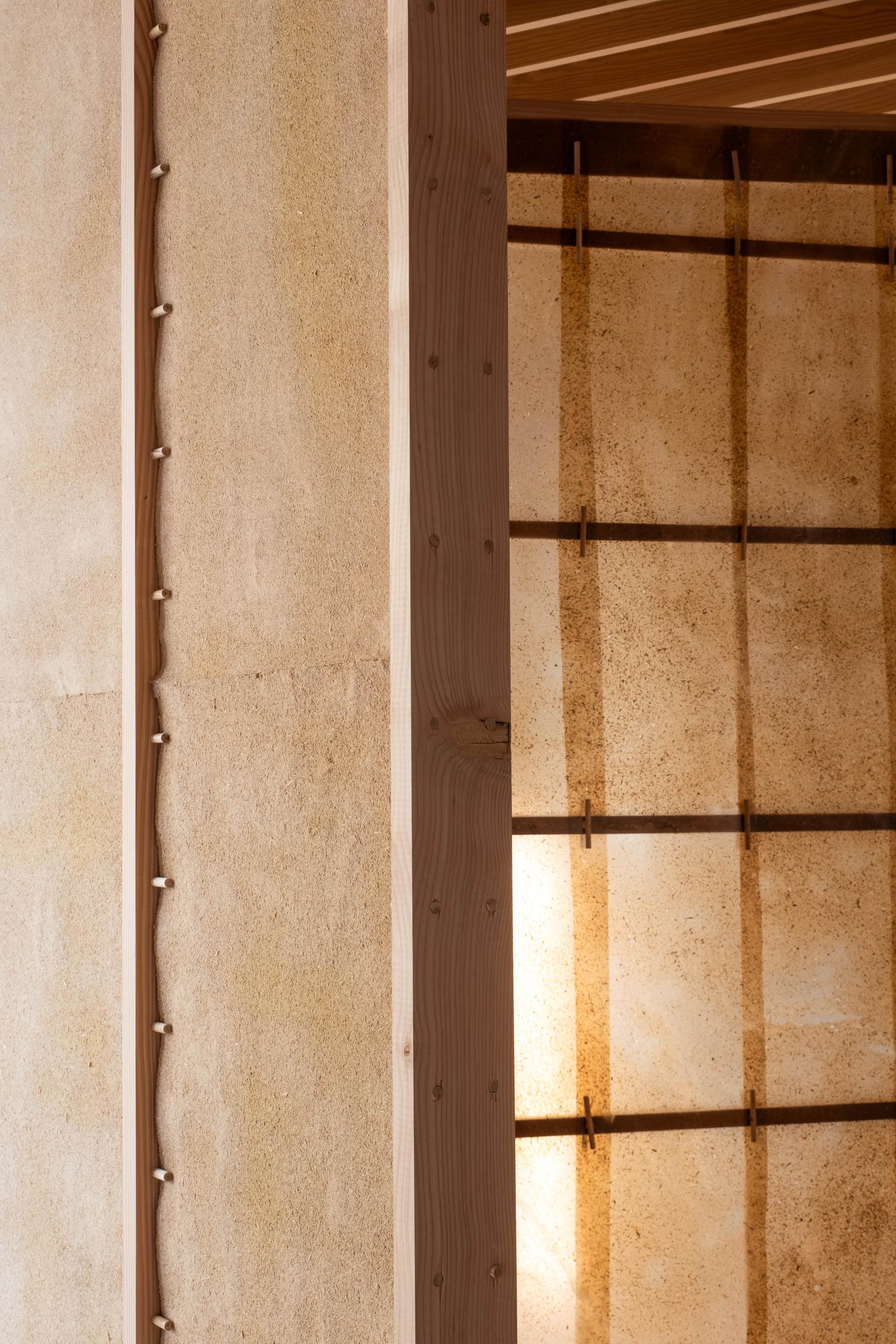 Detail of a wood and natural material installation featuring textured surfaces and architectural elements, highlighting innovative design aspects.