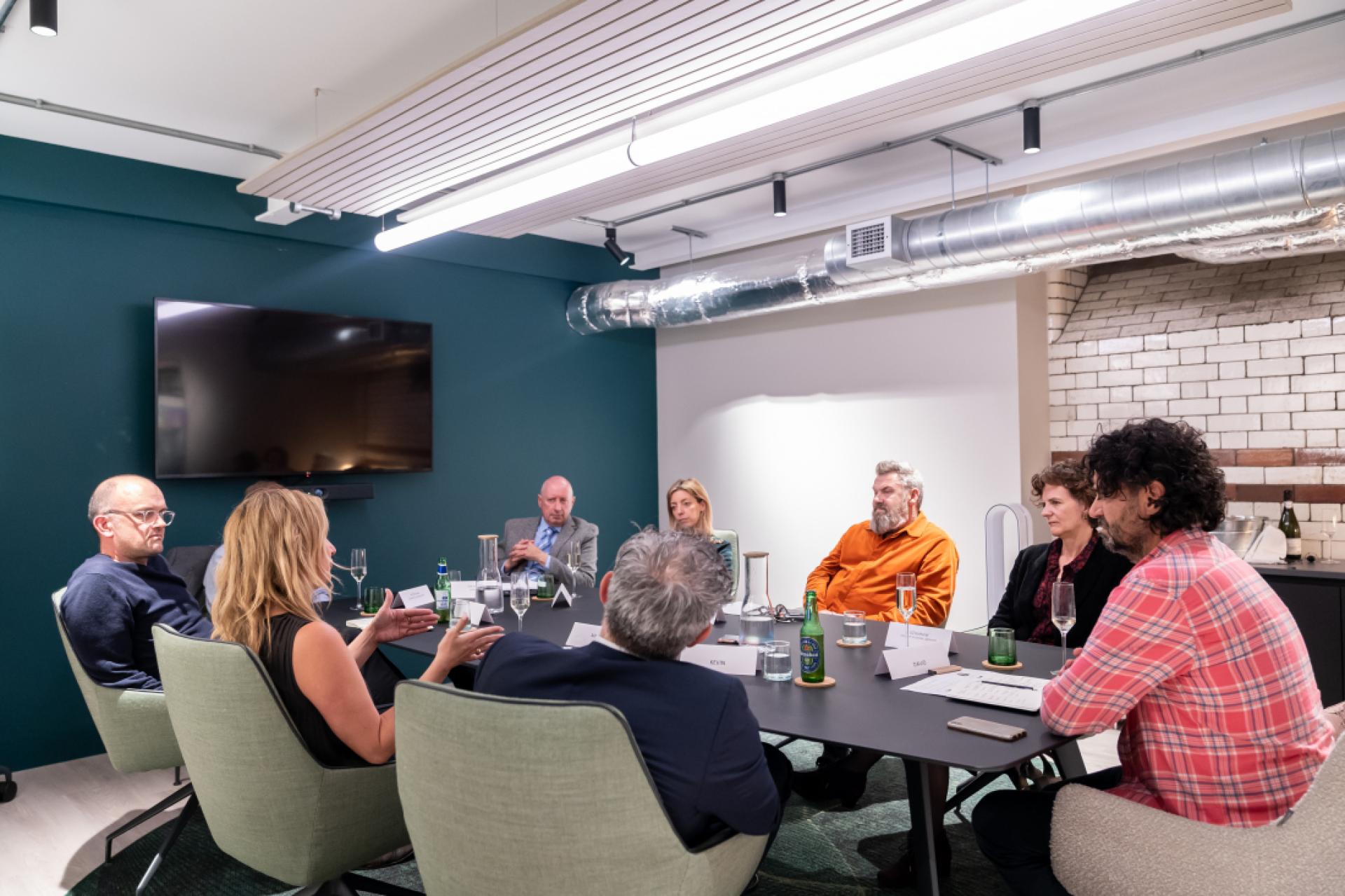 Group discussion among diverse professionals in a modern conference room, reflecting on insights from 2022.