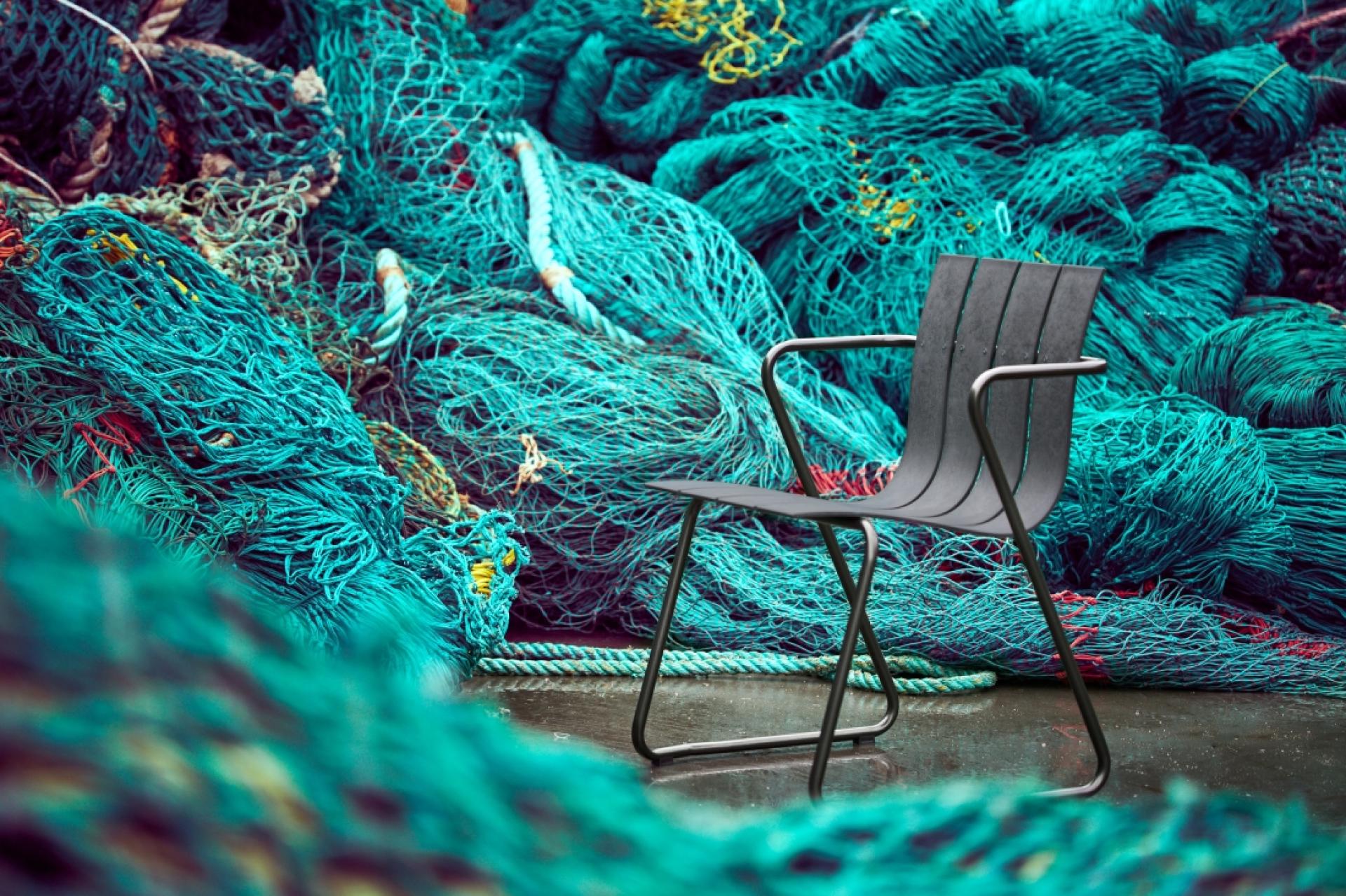 A sleek black chair sits in front of vibrant fishing nets, representing themes of innovation and environmental impact in 2019.
