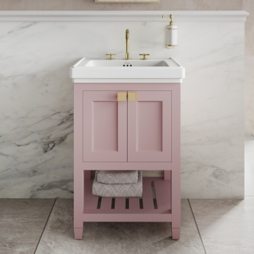 Elegant pink bathroom vanity with white countertop and brass fixtures, set against a marble backdrop, inspired by classic design.