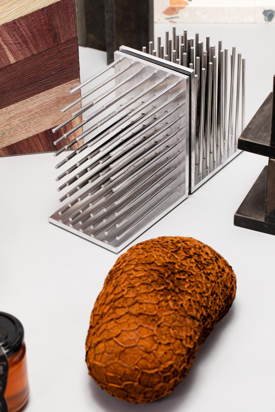 Natural and man-made materials showcase, featuring textured object, metal display, and wood samples for sustainable design exploration.