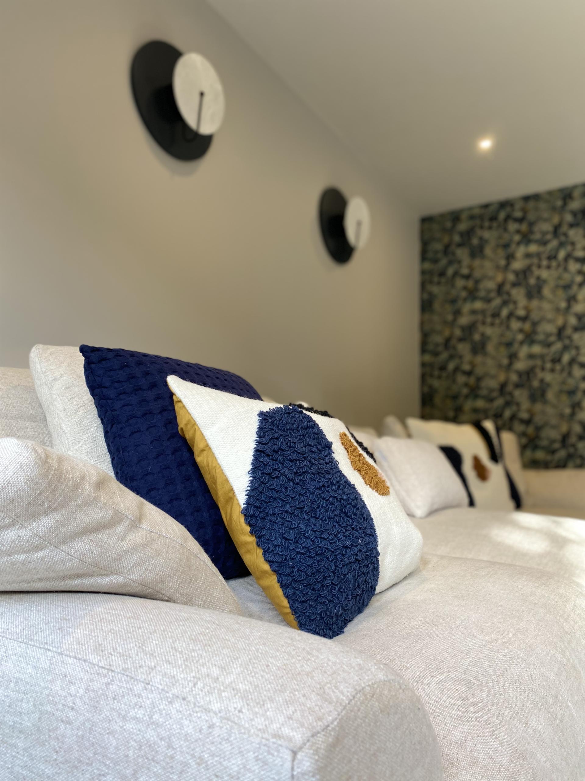 Stylish sofa adorned with textured cushions, showcasing modern design elements in a contemporary interior space.