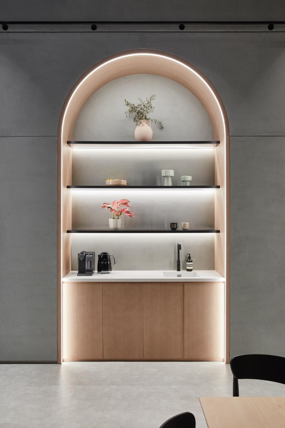 Stylish kitchen area with modern shelves, elegant decor, and appliances, showcasing Roar Studio's design in Dubai's ICD Brookfield Place.