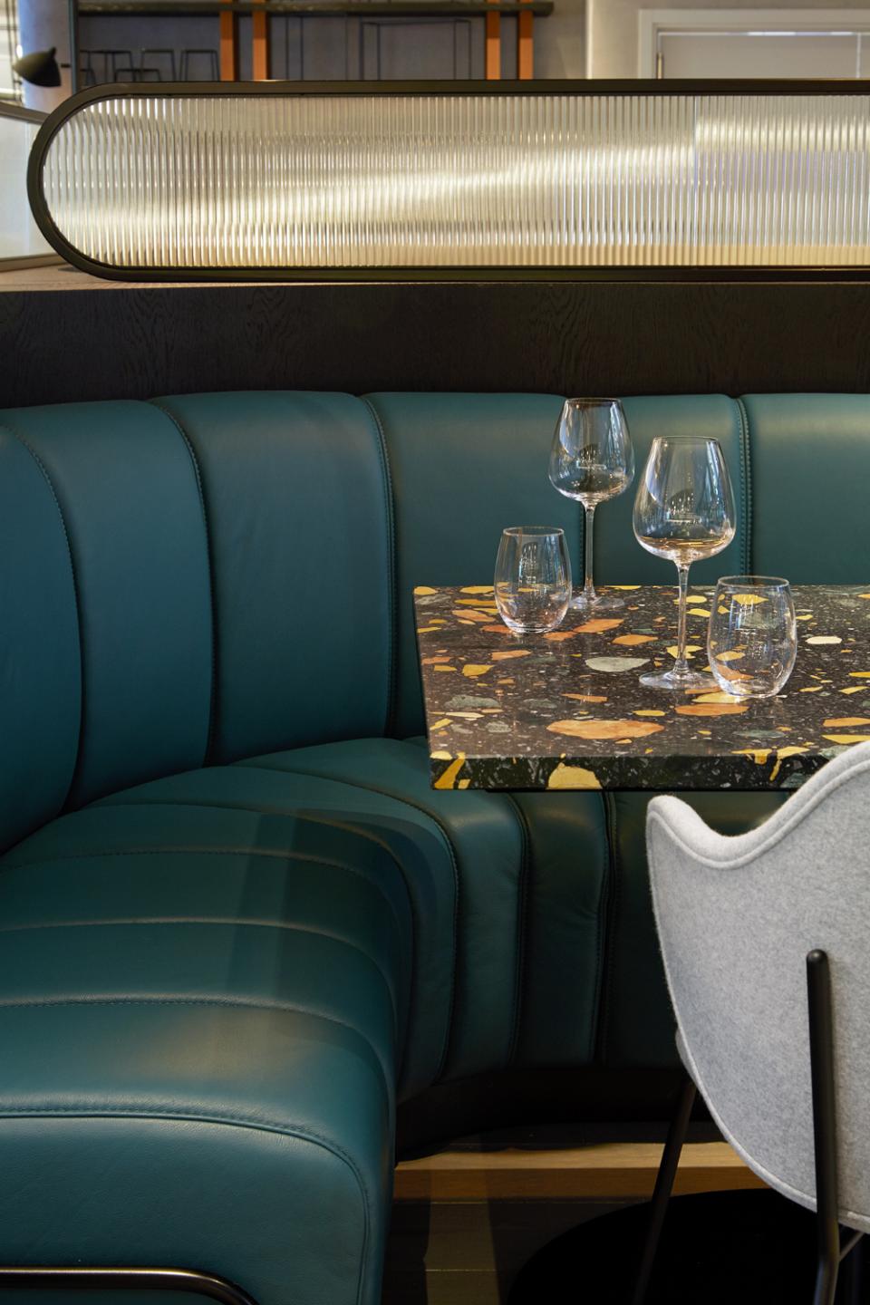 Stylish seating area at PURO Kraków Kazimierz featuring a marble table and elegant glassware designed by Conran+Partners.