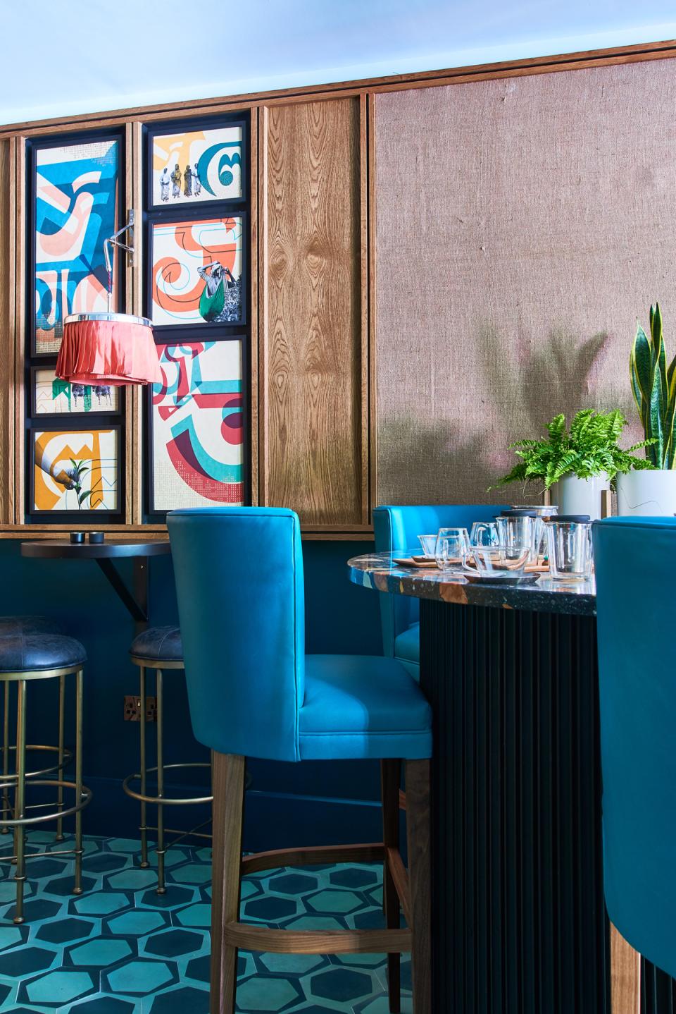 Stylish art deco interior of Teatulia's tea shop featuring vibrant wall art and turquoise seating.