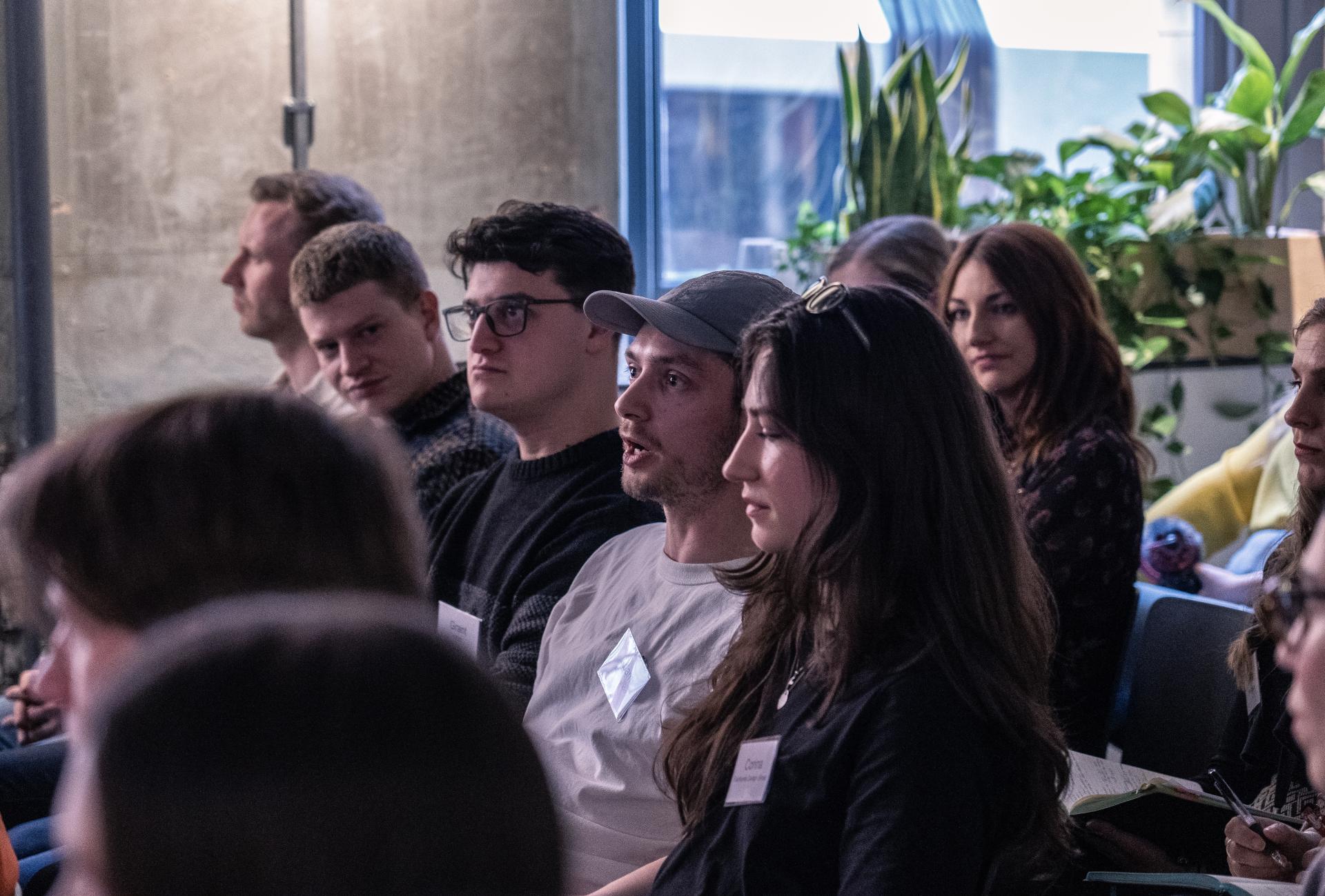 Diverse audience engaging in a discussion about technology at a Material Source Studio event.